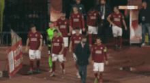 a group of soccer players are walking on a field and one of them has the number 29 on their shirt