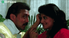 a man and a woman are looking into each other 's eyes . the woman is touching the man 's face .