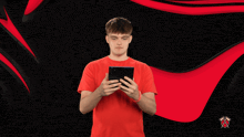 a man in a red shirt looks at a tablet