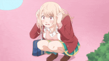 a girl with blonde hair is kneeling down with a blue bag