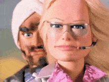 a woman wearing glasses and a headset stands next to a man with a turban