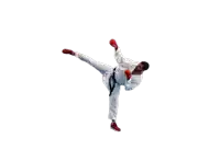 a man in a karate uniform is kicking a red ball
