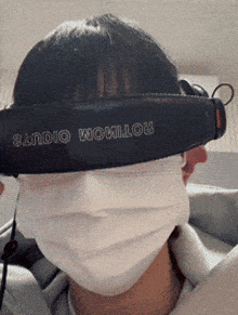 a man wearing a mask and headphones with the word studio on the strap