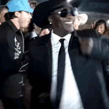 a man in a suit and tie is smiling and wearing sunglasses