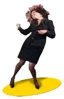a woman in a black suit and skirt is dancing on a yellow mat