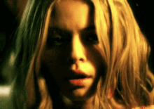 a close up of a woman 's face with blonde hair and red lips .