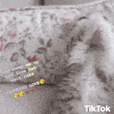 a pillow with a floral pattern and a tiktok logo on the bottom