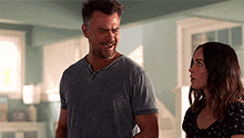 a man and woman are standing next to each other in a room .