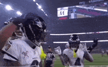a group of football players are standing on a field .
