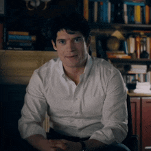 a man in a white shirt is sitting in a chair