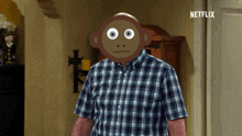 a man in a plaid shirt with a monkey face on his face