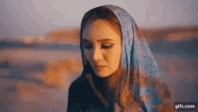 the woman is wearing a blue scarf around her head .
