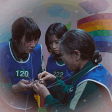 three women wearing blue vests with numbers 120 and 222 on them