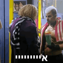 a man with a towel around his neck is talking to a woman in a locker room