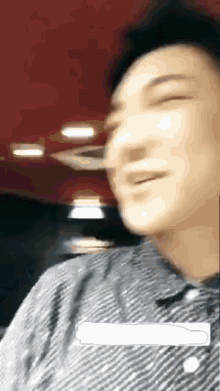 a man is smiling with his eyes closed in a blurry photo .