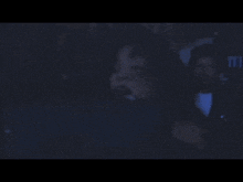 a blurry picture of a man in a suit and tie in a dark room