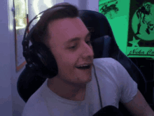 a man wearing headphones is smiling in front of a sign that says nuka cola