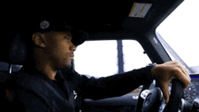 a man wearing a black hat is driving a car ..