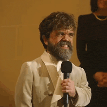 a man with a beard and curly hair is holding a microphone