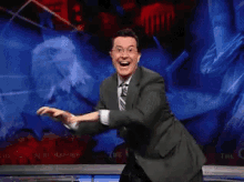 a man in a suit and tie is dancing on stage