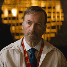 a man with a beard wears a lanyard that says " a " on it