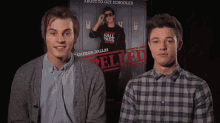 two young men are standing in front of a movie poster that says relied