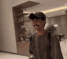 a man with a mustache wearing a hat and a t-shirt with a skull on it is smiling