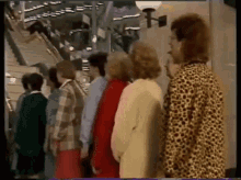 a group of women are standing in a line in front of stairs