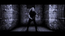 a man is playing an electric guitar in a dark room .