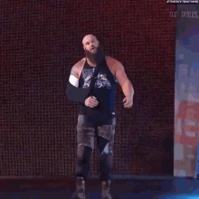 a wrestler with a beard and a cast on his arm is walking on a stage .