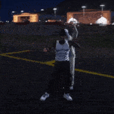 a man in a white shirt is dancing with another man in a white jacket