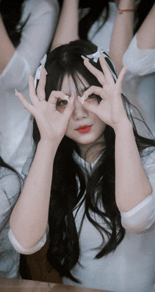 a girl covering her eyes with her hands while another girl looks on