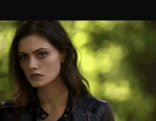 a close up of a woman wearing a black leather jacket