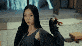 a woman with long black hair is wearing a black jacket
