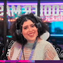 a woman wearing headphones is smiling in front of a sign that says 2am