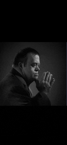 a man with down syndrome is wearing a suit and tie in a black and white photo