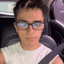 a man wearing glasses is taking a selfie in a car with margaritosgif written in the corner