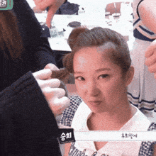 a woman is getting her hair done by a person with a label that says ' s ' on it