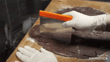 a person is cutting a piece of dough with an orange spatula and the words made in animotica are visible