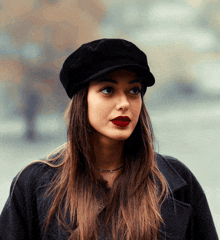 a woman wearing a black hat with red lipstick