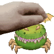 a hand is reaching out towards a green monster with spider legs .