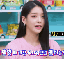 a woman in a pink sweater is talking in a foreign language