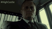 a man in a suit and tie is sitting in a car with the hashtag #highcastle
