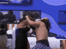 a man and a woman are fighting in front of a tv that says ' lity oficial '