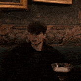 a man sits on a couch holding a martini glass in his hand
