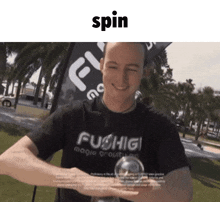 a man wearing a fushigi shirt is smiling and holding a ball