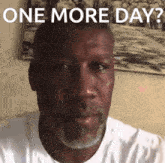 a man with a beard and a white shirt says one more day