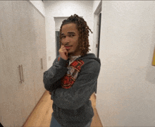 a man with dreadlocks is standing in a hallway