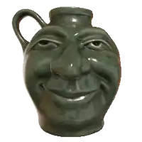 a green vase with a face on it looks like a man 's head