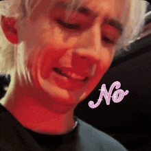 a close up of a man 's face with the word no in pink